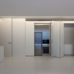 A white kitchen with white cabinets and a refrigerator.