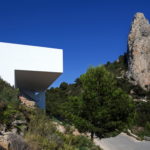 A white building sits on the side of a mountain.