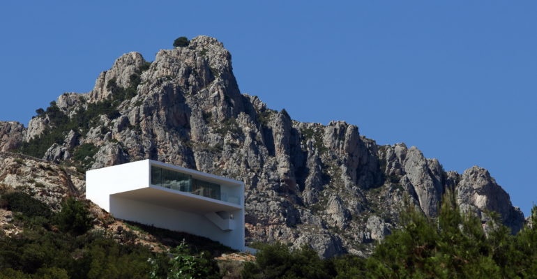 A white house sits on top of a mountain.