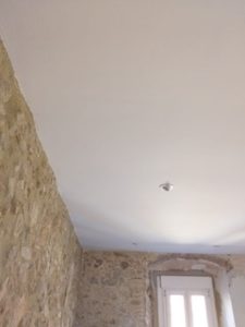 A Costa Blanca South property for sale featuring a room with a stone wall and a white ceiling.