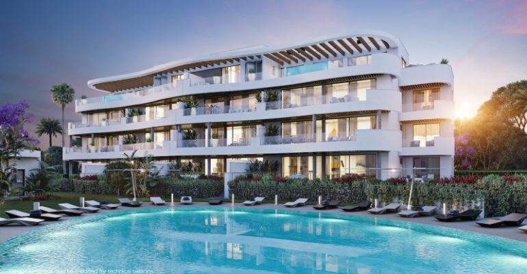 A newly built apartment complex with a swimming pool and lounge chairs, available for sale in Fuengirola or Malaga.
