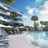 A new build apartment complex in Higueron West featuring a swimming pool and lounge chairs.