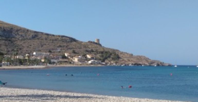A beach with a mountain in the background, perfect for Murcia property investment.