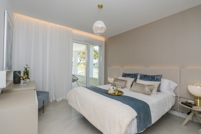 A new build apartment in Cadiz featuring a bedroom with a bed and bedside table.