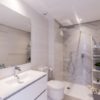 A modern white bathroom with a toilet, sink and mirror in a new build penthouse in San Roque.