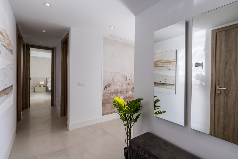A New build San Roque penthouse with a mirror and a plant in its hallway.