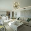 A San Roque New Build apartment furnished with white furniture and a chandelier.