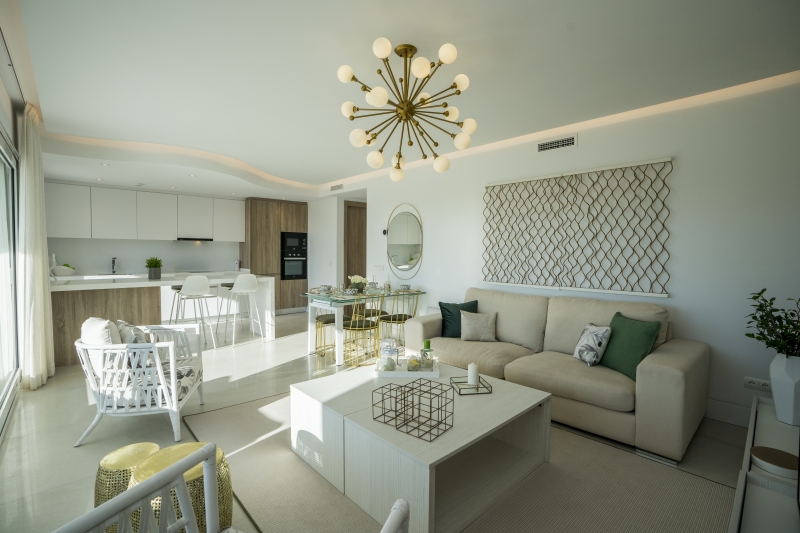 A San Roque New Build apartment furnished with white furniture and a chandelier.