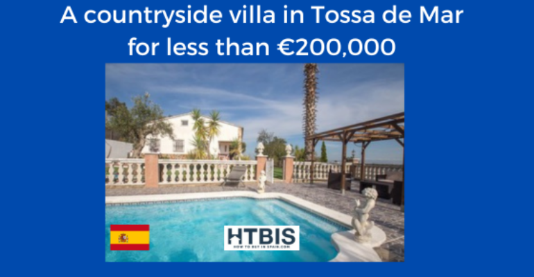 Photo of a charming countryside villa in Tossa de Mar with a pool, surrounded by a patio. An advertisement banner indicates this property for sale in Costa Brava is available for less than €200,000 and shows the Spanish flag.
