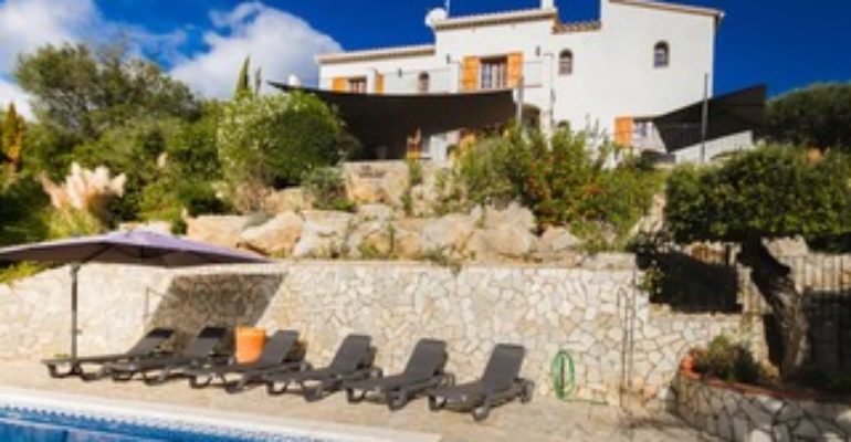 A holiday villa with a swimming pool and sun loungers for sale in Calonge, Costa Brava.