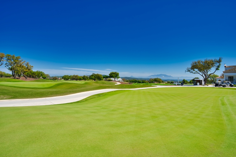 A green golf course with a house in the background. Keywords: Cadiz