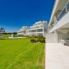 A new build apartment complex featuring a grassy lawn and swimming pool in San Roque, Cadiz.