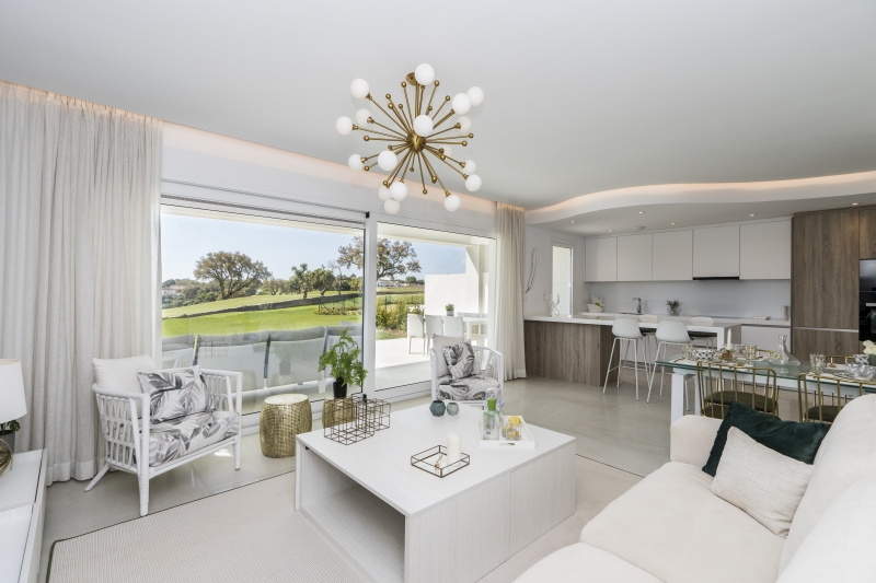 A white living room with a view of the golf course in a New build penthouse.