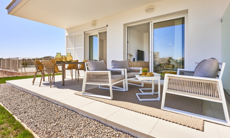 New build apartment in Cala d'or with a patio featuring a table, chairs, and glass door.