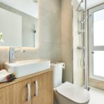 A new build apartment in Cala d'or with a modern bathroom featuring a sink, toilet, and shower.