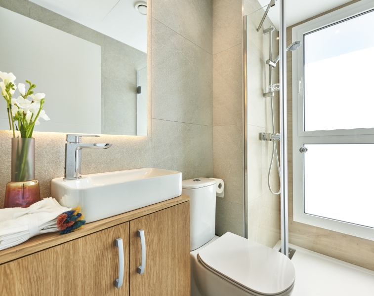 A new build apartment in Cala d'or with a modern bathroom featuring a sink, toilet, and shower.