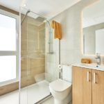 New build apartment in Cala d'or with a modern bathroom featuring a glass shower stall and toilet.