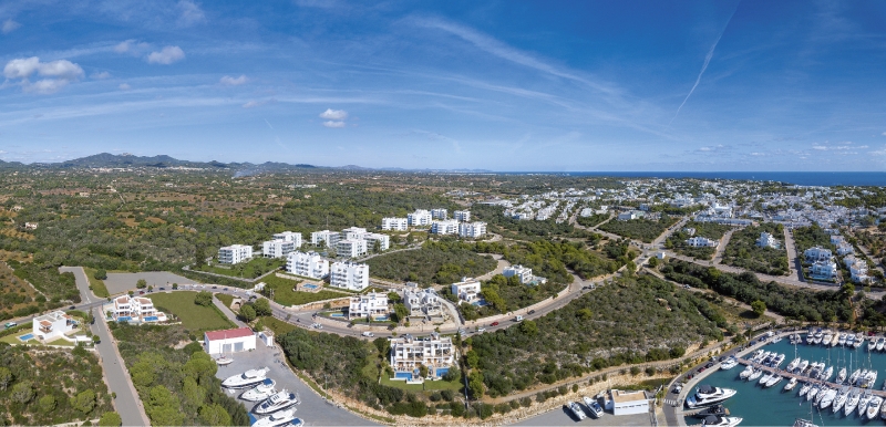 An aerial view of a new build apartment complex and marina in Cala d'or, Mallorca.