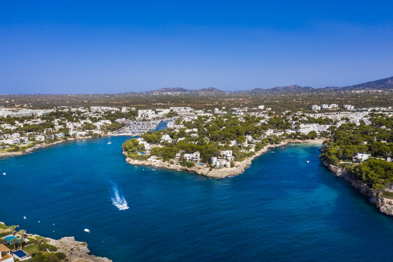 An aerial view of a bay with boats in the water, showcasing the new build apartment in Mallorca.