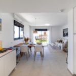 A modern apartment with a white kitchen and dining room in Alicante for sale.