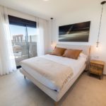 A cheap bedroom with a bed and a bedside table in a Gran Alicante New Build Apartment.