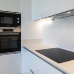 A white kitchen with a stove and oven in an Alicante New Build Apartment.