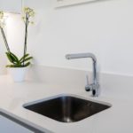 A white sink in a kitchen for sale.