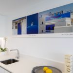 A white kitchen with a picture on the wall in an Alicante New Build Apartment.