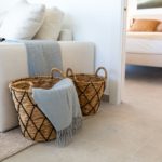A living room with wicker baskets in front of a bed in a Gran Alicante New Build Apartment.