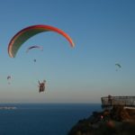 Paragliding on a cliff overlooking the ocean with stunning views.