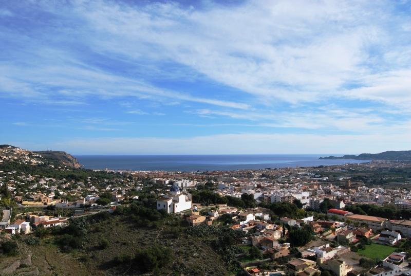 A view of a town from the top of a hill, showcasing cheap Alicante property for sale.