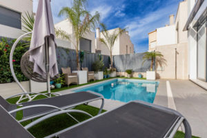 An Orihuela Costa villa with a swimming pool and lounge chairs.