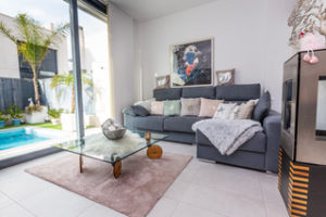 An Orihuela Costa villa living room with a couch and a glass door to the pool.