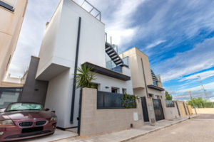 A modern Orihuela Costa villa with a car parked in front of it.