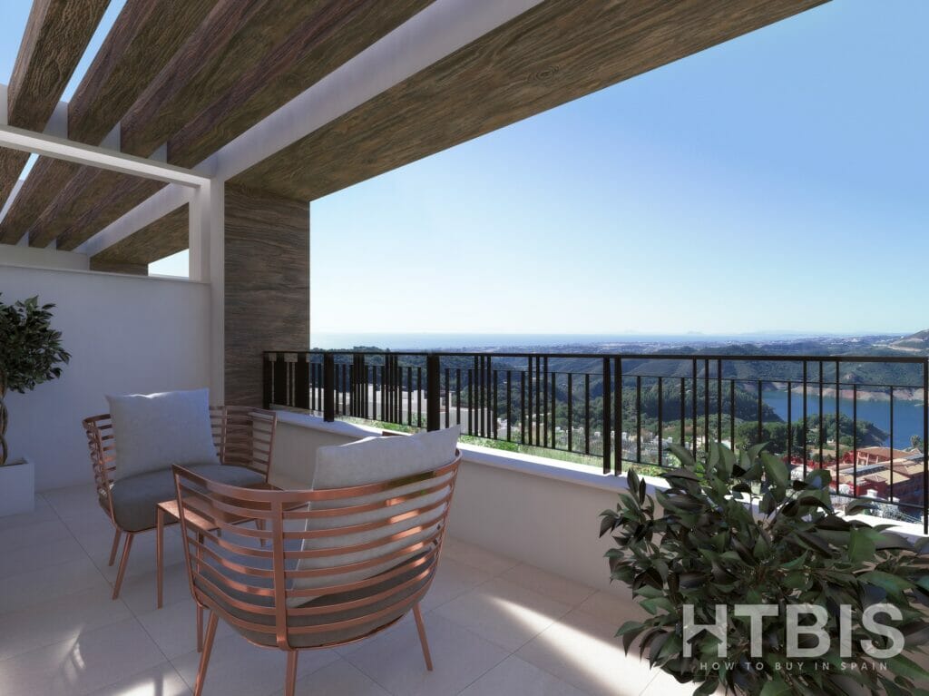 A view of a penthouse balcony in Malaga with furniture and a view of the sea.