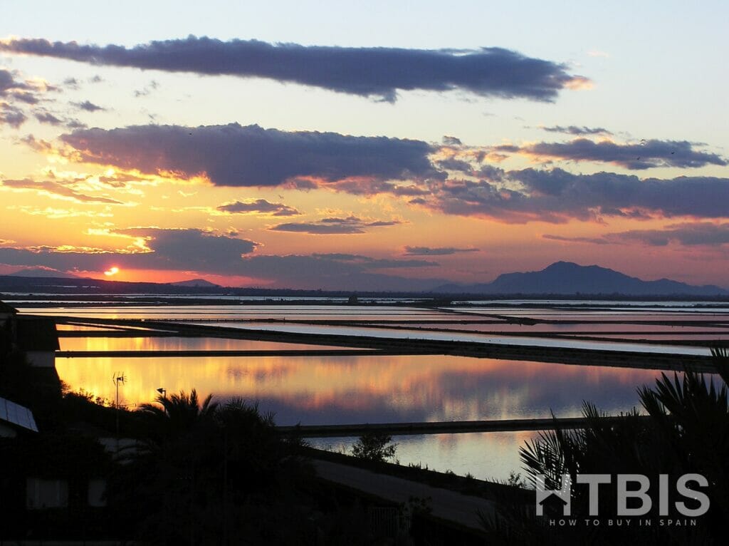 The sun is setting over a body of water, visible from the new build apartment in Gran Alicante.