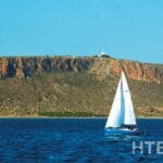 A sailboat in the water near a cheap Alicante property for sale.
