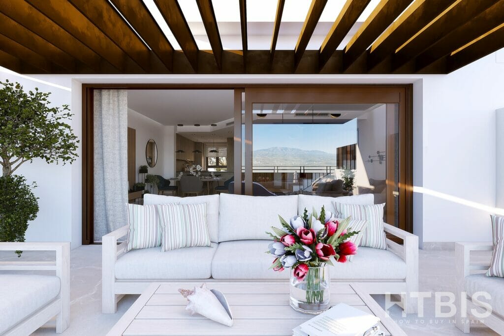 A white patio with furniture and a view of the ocean, part of Belaria La Cala resort.