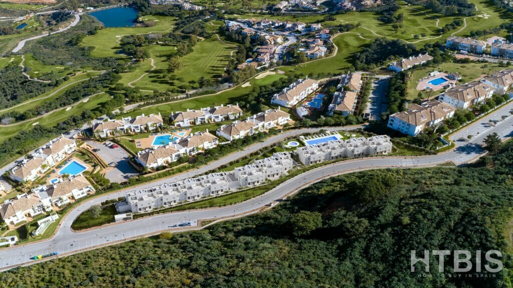 An aerial view of a golf course and apartments at the Belaria La Cala resort.
