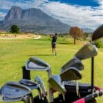 Golf clubs in a bag with a mountain in the background, overlooking a cheap Alicante property for sale.