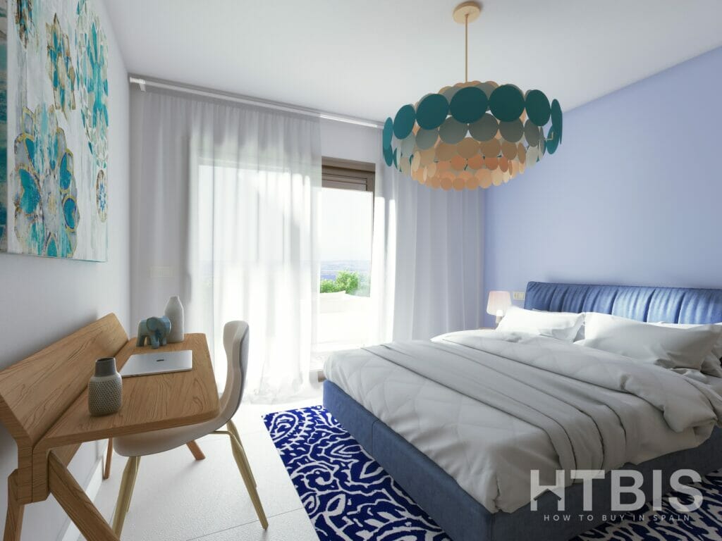 A blue and white bedroom with a bed and a desk in an apartment in Malaga.
