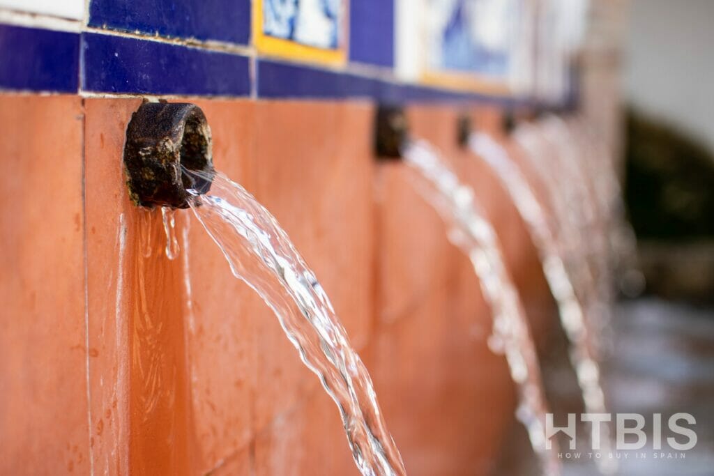 Water coming out of a pipe on the wall of an apartment in Malaga.
