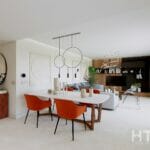 A modern living room in a Malaga New Build Apartment with orange chairs and a dining table.