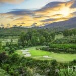 A golf course in the mountains at sunset near a Marbella New Build apartment.