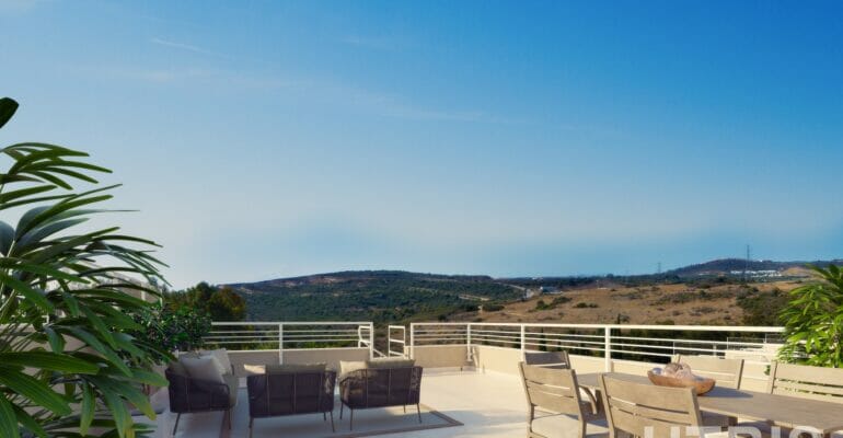 A balcony with furniture and a view of the mountains overlooking the Estepona Golf Course.
