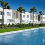 An apartment complex with a swimming pool, palm trees, and views of the Estepona Golf Course.