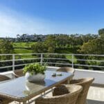 A balcony with a table and chairs overlooking the Estepona Golf Course.