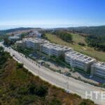 An aerial view of an apartment complex on a hillside overlooking the Estepona Golf Course.