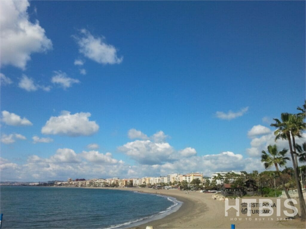 A beach near Estepona Golf Course with palm trees and a blue sky.